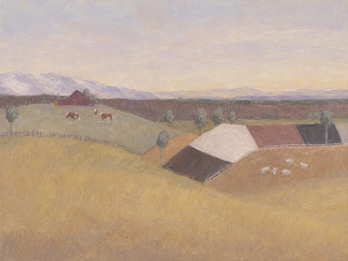 A farm with a red barn and grazing cattle below distant mountains